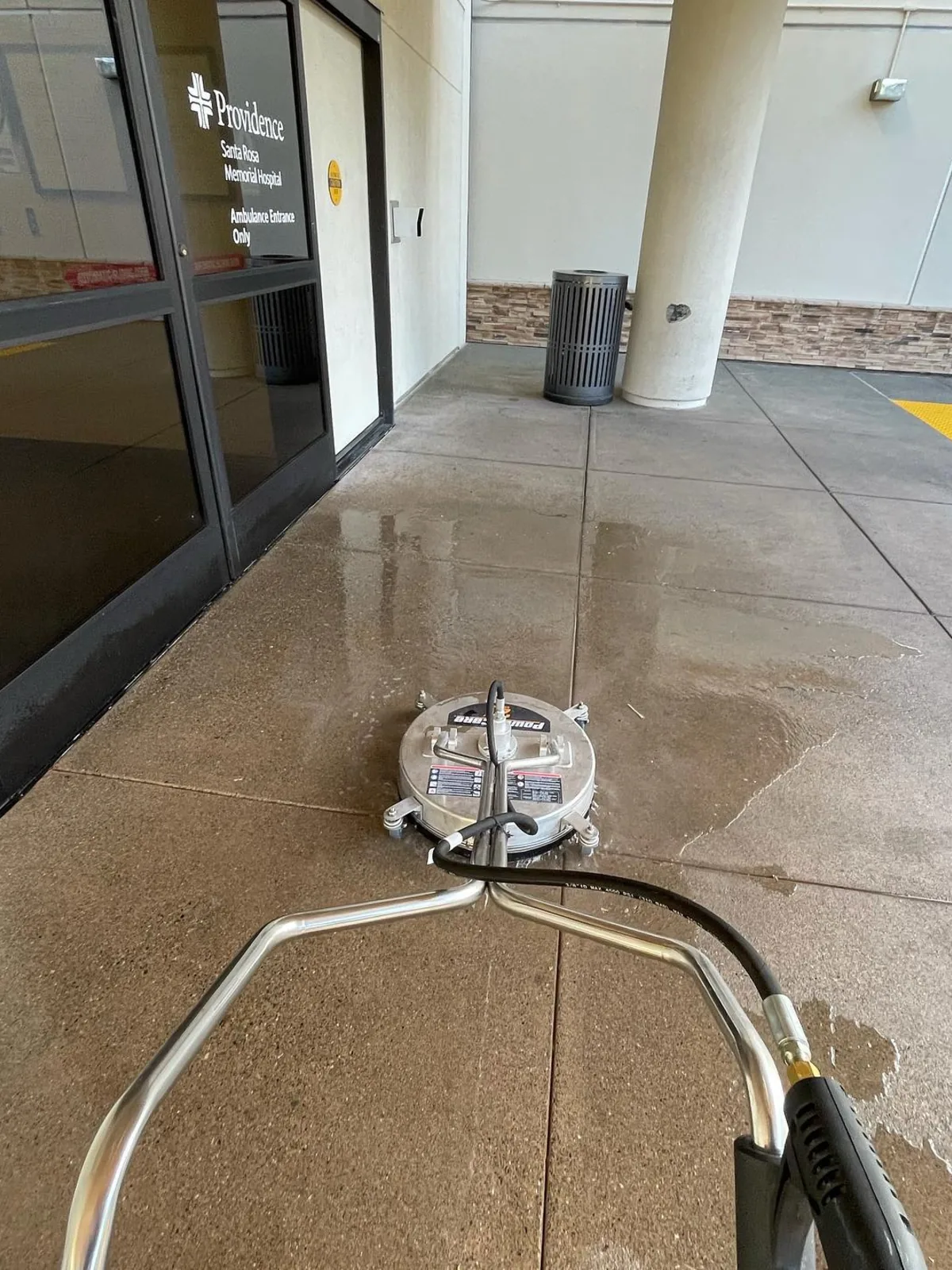 Rotary surface cleaner pressure washing a concrete walkway