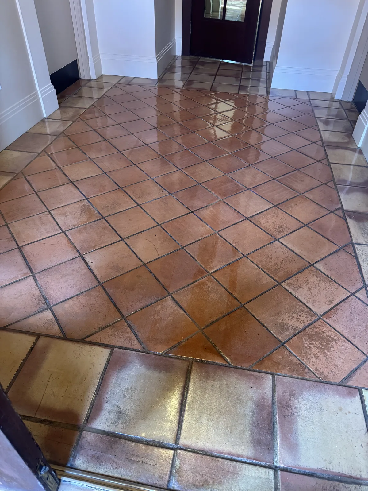 Sealed terracotta tile floor at a building entry