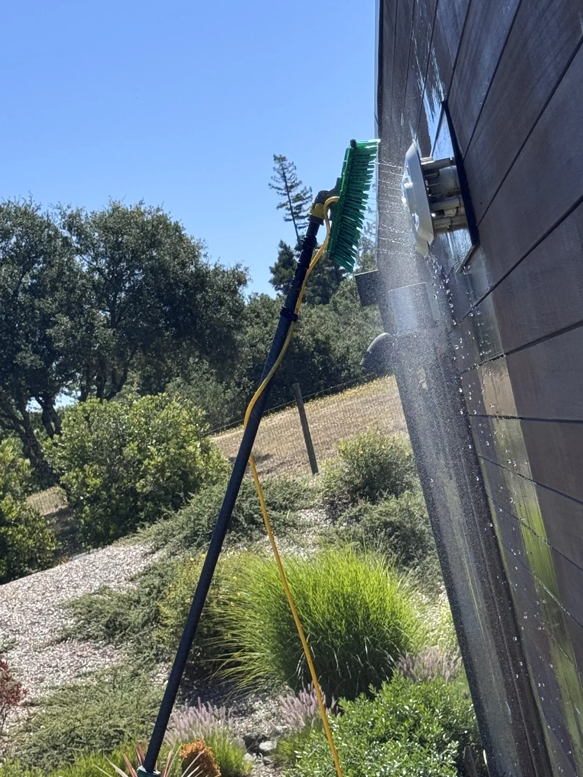 Water-fed pole cleaning windows on a building exterior