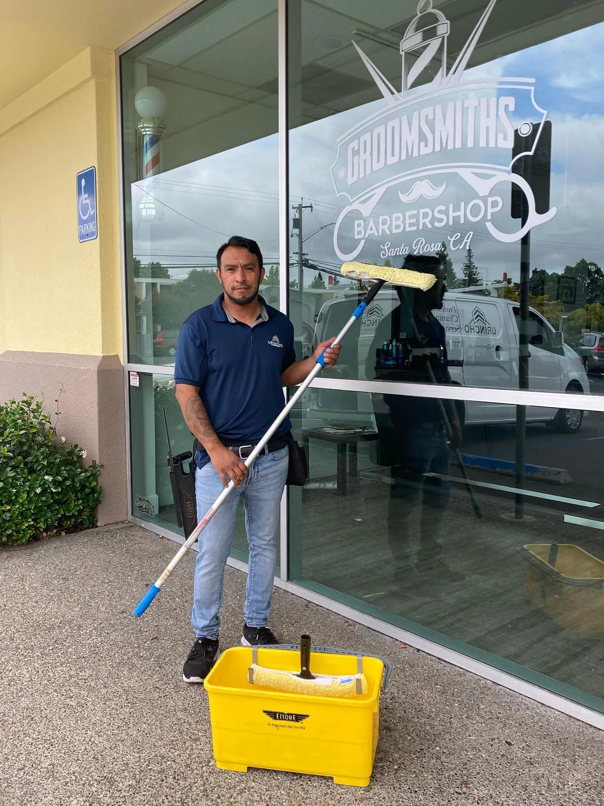 Technician cleaning storefront glass with a wash pole